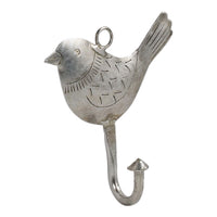 The Ashika Iron Bird Hook is a silver, bird-shaped wall hook with engraved details, a loop on top, and an upward-curving hook at the bottom for added storage.