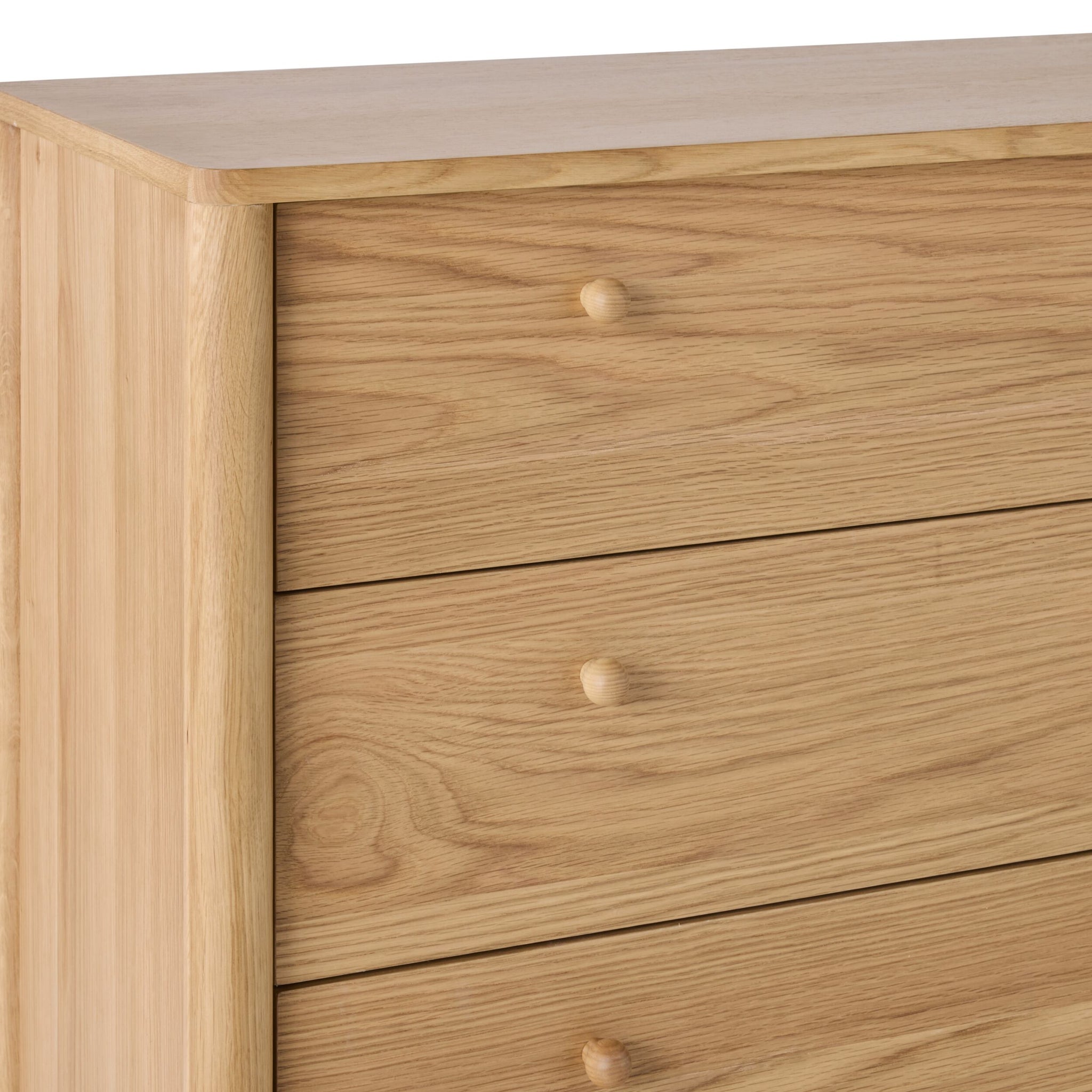 A close-up of the Spintara 4 Drawer Chest Light Oak, showcasing its four drawers with round wooden knobs and a natural light oak finish—a stylish complement to your bedroom décor.
