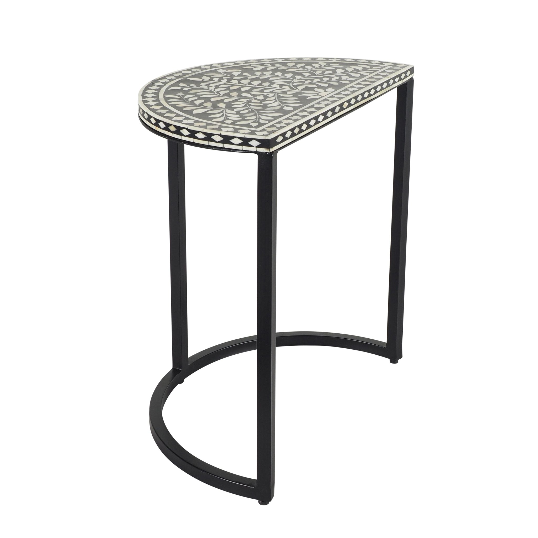 The Bone Inlay Half Moon Side Table features a black and white design with a patterned top and sleek metal legs, reminiscent of an elegant bone inlay side table.